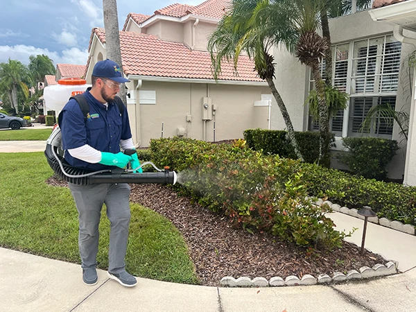 A tech spraying for pests in front of a Florida home | Forest Pest Control