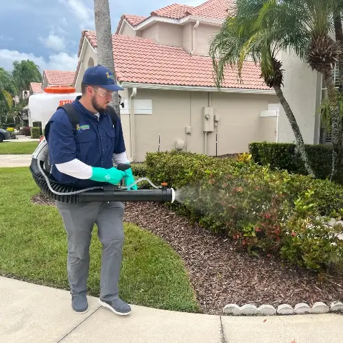 A Florida Pest Control technician spraying for pests in front of a Central Florida home