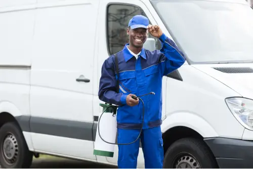 Pest Exterminator in Front of a Work Truck with Insecticide Equipment