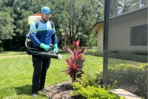 Forest Pest Control technician performing pest control spraying service outside of a home in Central Florida